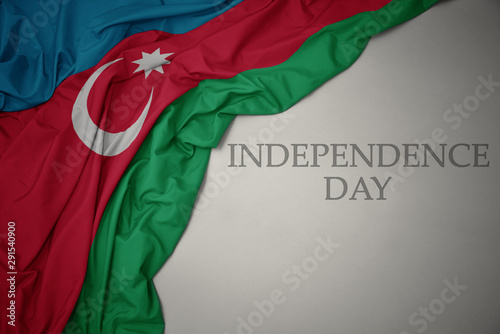 waving colorful national flag of azerbaijan on a gray background with text independence day. photo