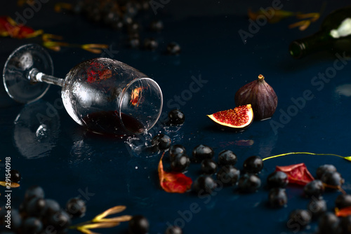 Autumn wine with grape on blue handmade table.