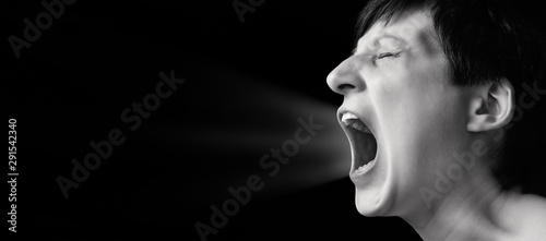 Concept of anger. Portrait of a screaming woman on isolated background with free space. Black and white image. © svetazi