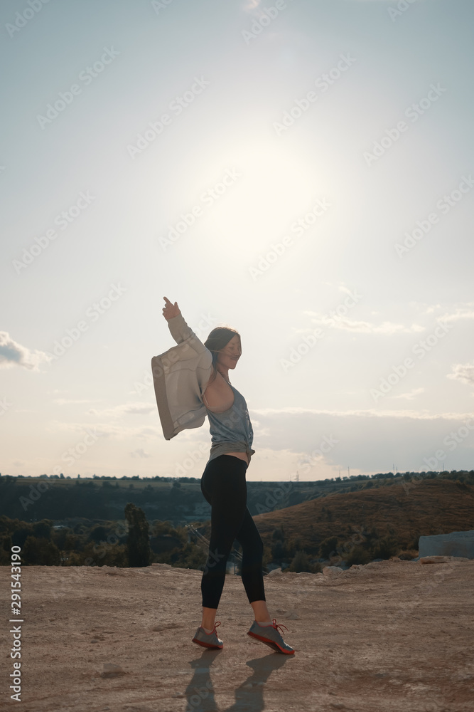 Young girl walks in a career sunny summer evening Young girl walks in a career sunny summer evening