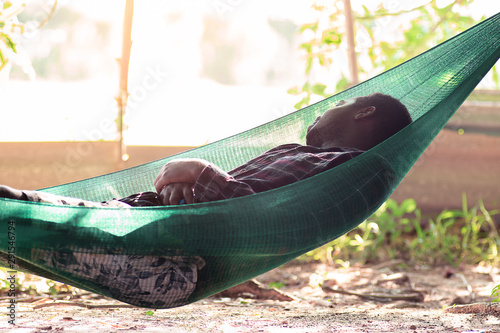 African man sleeping on a green cradle or cot