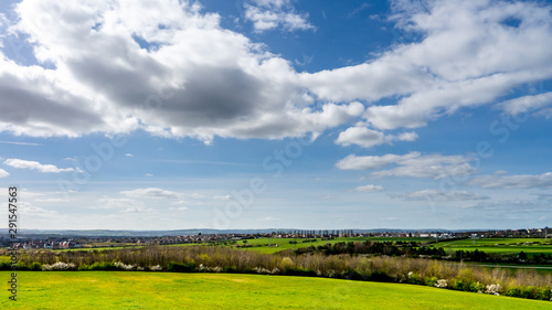 Landscape showing parts of Herrington Country Park in Sunderland Tyne and Wear.  Featuring blue sky, clean white clouds and lush green fields on a warm sunny day.