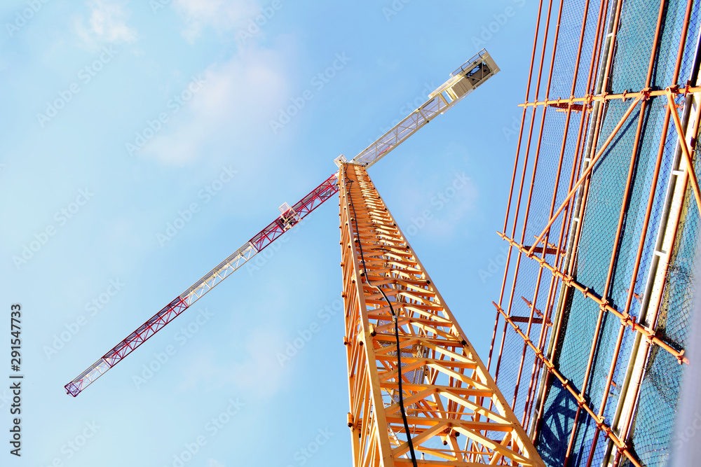 Fototapeta premium Construction - A large crane reaches for the sky