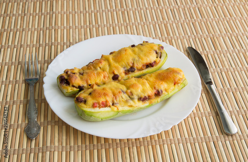 Zucchini boat with chicken, beans and vegetables under cheese