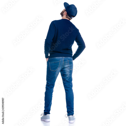 Man in jeans shorts, cap, casual clothing standing looking up on white background isolation, rear view © Kabardins photo