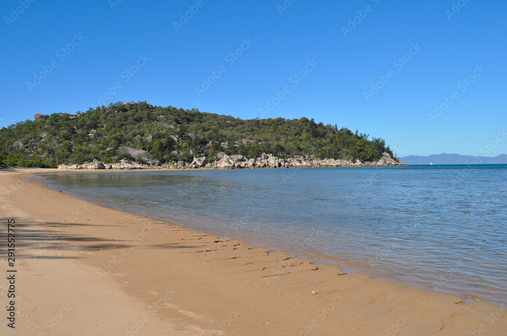 Beach scene at Picnic Bay on Magnetic Island, Queensland, Australia, looking to the headland and beyond to the mainland near Townsville.