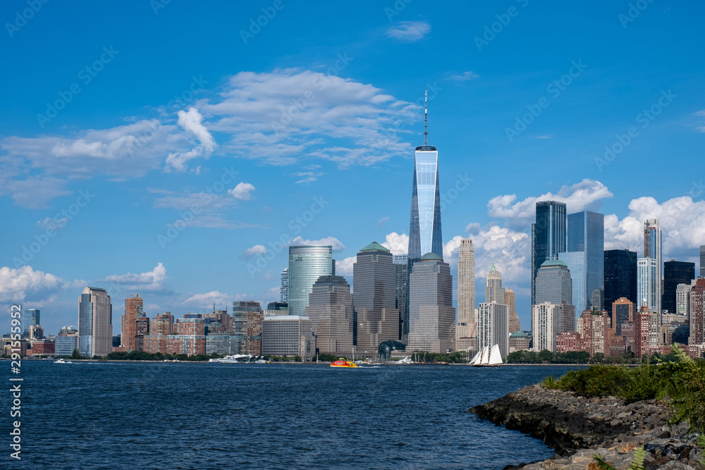 Fototapeta premium Lower Manhattan skyline with boat and ferry on Hudson river view from Liberty State Park in late summer
