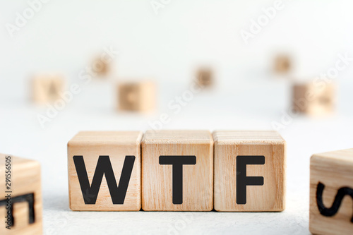 WTF - word from wooden blocks with letters, WTF concept,  top view on grey background