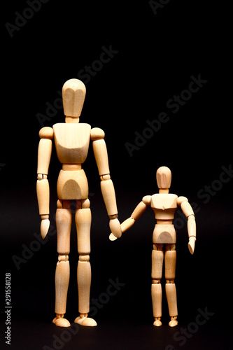 Conceptual image of a manikin parent and child holding hands