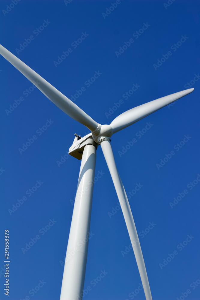 Close up view of the propellers on a giant wind turbine, with blue sky background Close up view of the propellers on a giant wind turbine, with blue sky background