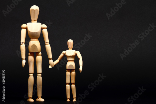 Conceptual image of a manikin parent and child holding hands with space for copy