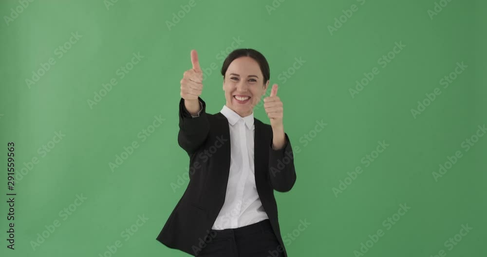 Cheerful businesswoman giving thumbs up gesture over green background Cheerful businesswoman giving thumbs up gesture over green background