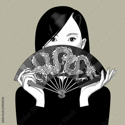 Chinese girl girl covers her face with a fan with a dragon