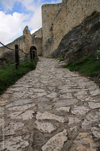 Stone paved path leading to an ancient fortress on a hill.