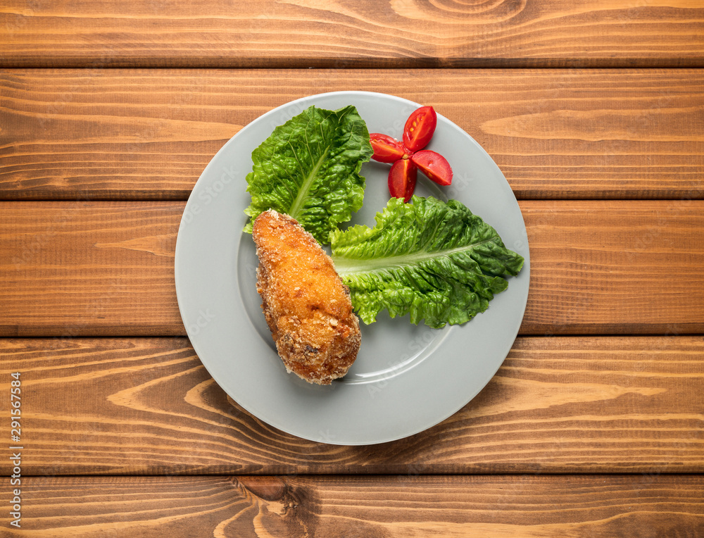 Fried chicken with greens and tomatoes.