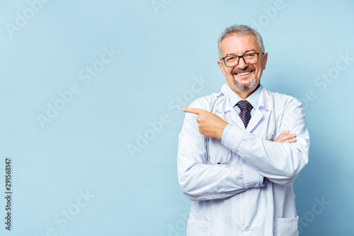 Cheerful mature doctor posing and smiling at camera, healthcare and medicine.