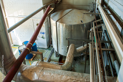 Equipment for preparation of beeer..Lines of metal tanks in modern brewery. Manufacturable process of brewage. Mode of beer production. Inside view of modern brewhouse with stainless barrels photo