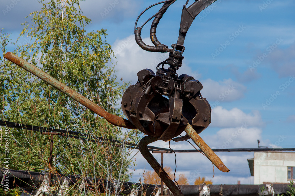 Mechanical grabbing arm manipulator on construction site for the removal of construction waste. A mechanical arm for moving goods.