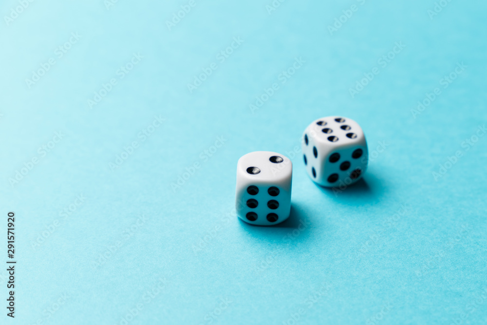 White gaming dice on blue background. Top view. Flat lay. Copy space. Game of chance concept. Close-up. Pastel colors White gaming dice on blue background. Top view. Flat lay. Copy space. Game of chance concept. Close-up. Pastel colors