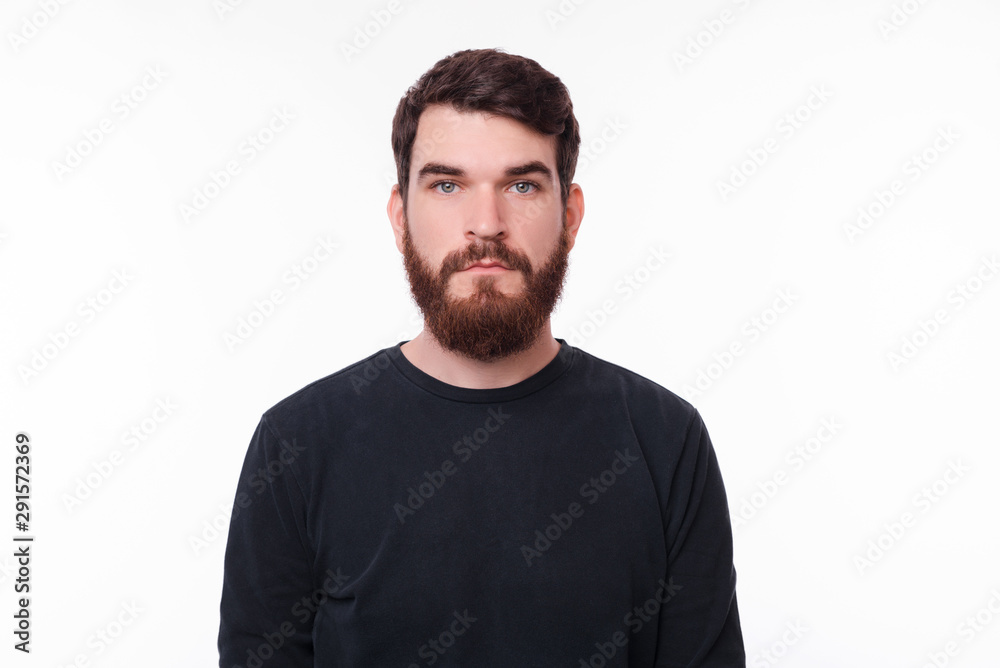 Portrait of serious young man with beard looking at the camera Portrait of serious young man with beard looking at the camera