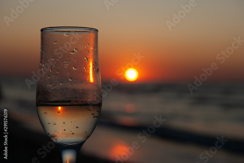 Glass of wine on sunrise, sunset background photo