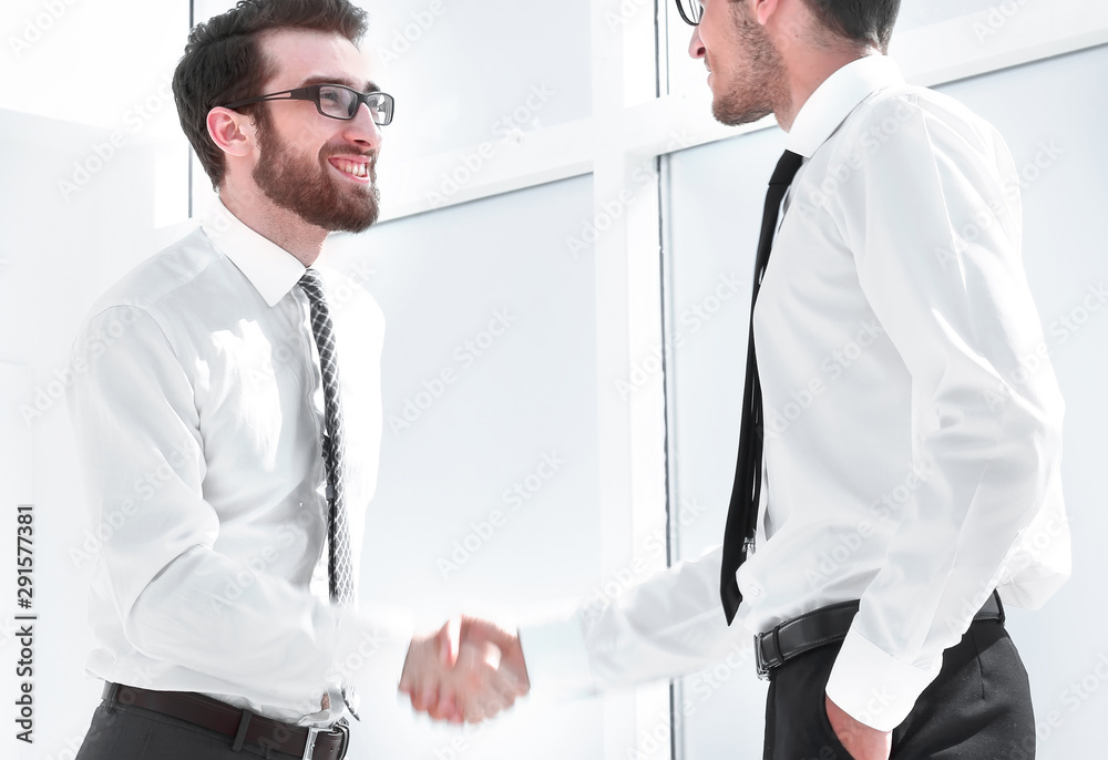 happy colleagues shaking hands with each other