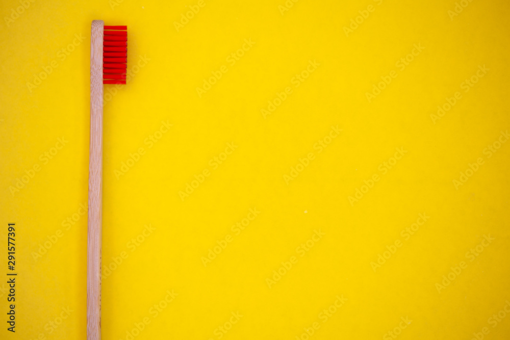 Eco bamboo toothbrush, organic on a yellow background, colored bristles, top view, top view. The concept of nature, environment, zero, zero plastic, a place for text. Eco bamboo toothbrush, organic on a yellow background, colored bristles, top view, top view. The concept of nature, environment, zero, zero plastic, a place for text.