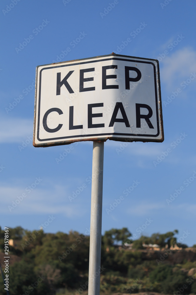 Keep clear road sign in blue sky background, vertical. Keep clear road sign in blue sky background, vertical.