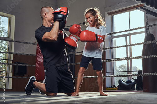 Young boxer trainer is training new girl boxer for special competitions.