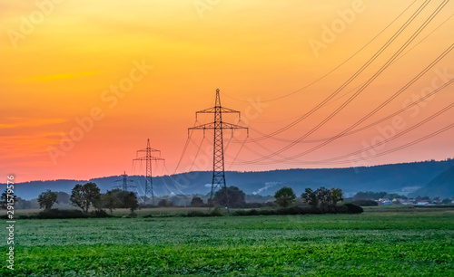 High voltage electricity pylons and transmission power lines on the blue sky background.