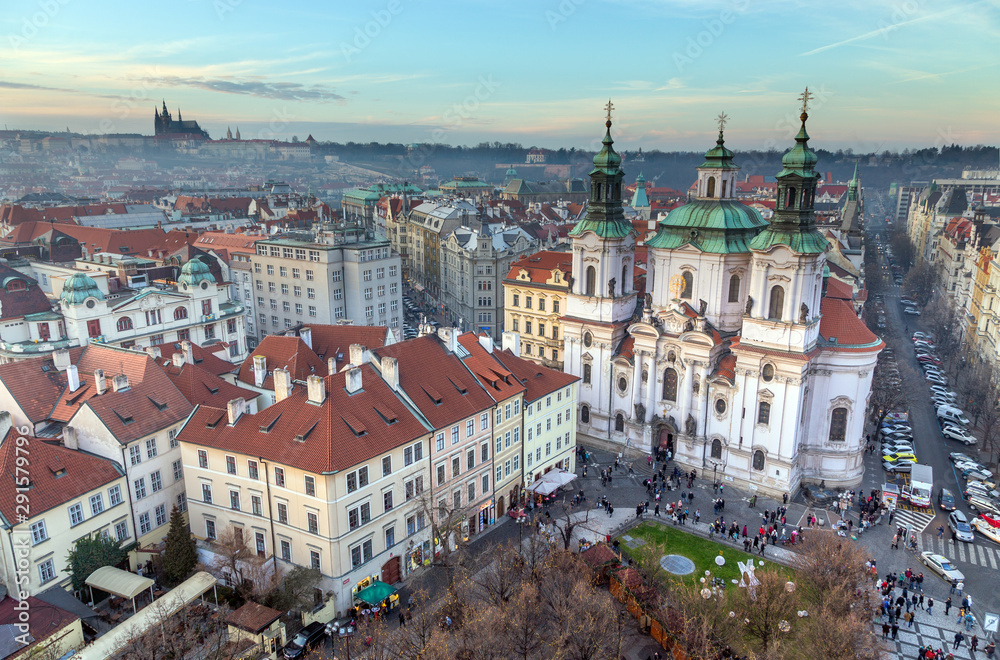 Panoramic view of Prague at sunset, St. Nicholas Church on the foreground, Czech Republic.