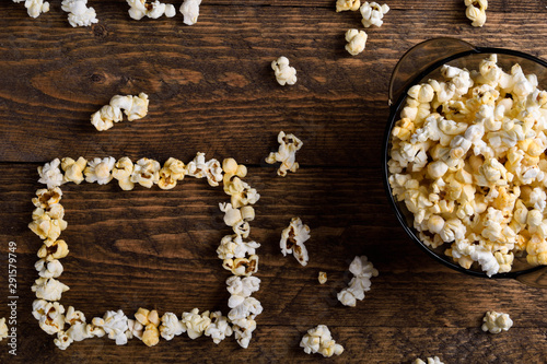Air salty popcorn.A bowl of popcorn on a wooden table.Salt popcorn on the wooden background . With space for text.Top view.popcorn texture.Chees .