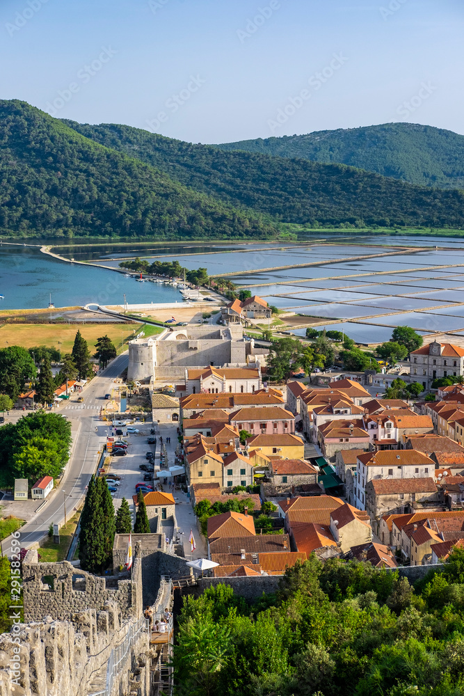 Beautiful scenery panoramic view of the small old town Ston with houses with red roofs and salt pans, Peljesac Peninsula,  Dalmatia, Croatia   