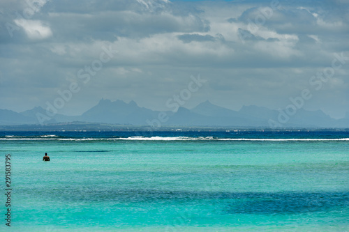 A man takes profit of the paradise beach of Pointe des Canonniers, Indian Ocean, Mauritius island 