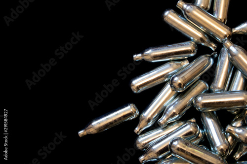Nitrous Oxide Metal Bulb Canisters Recreational Drugs on Black Background