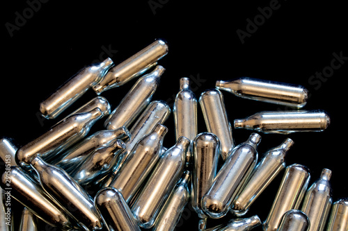 Nitrous Oxide Metal Bulb Canisters Recreational Drugs on Black Background photo