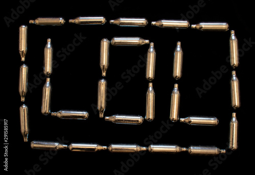 Nitrous Oxide Metal Bulb Canisters Recreational Drugs on Laugh Haha Word Lol Black Background