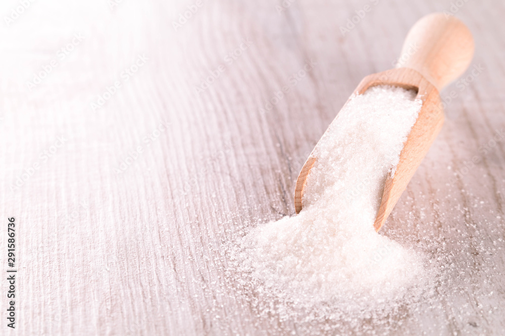 Fototapeta premium White cane sugar on a light wooden background