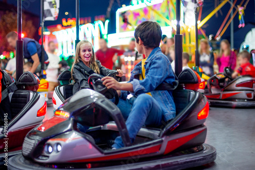 smiling boy and girl Dodgem Cars on bright ground