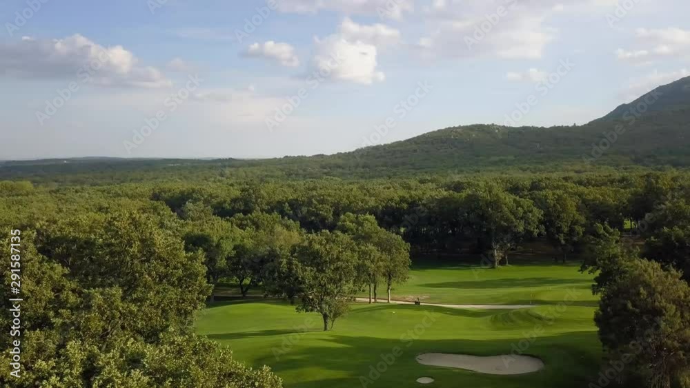 golf course in a forest of ash with the historic monastery of escorial crowning a hill, aerial view over fairway golf course in a forest of ash with the historic monastery of escorial crowning a hill, aerial view over fairway