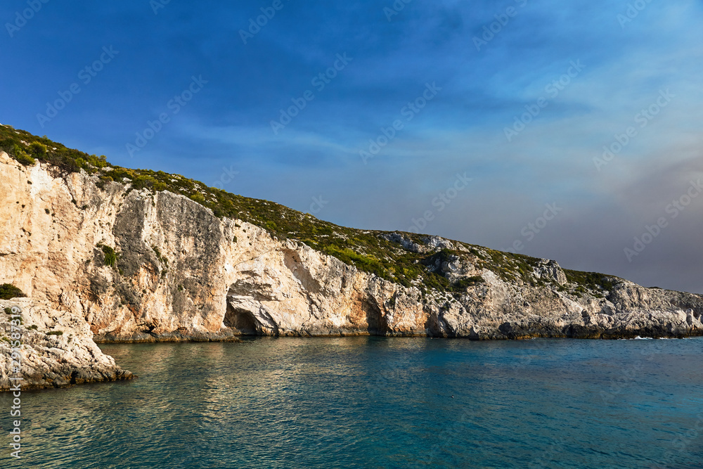 Stone cliff with caves on the island of Zakynthos in Greece.