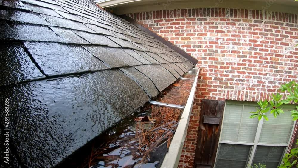 Clogged gutter full of water during rain storm