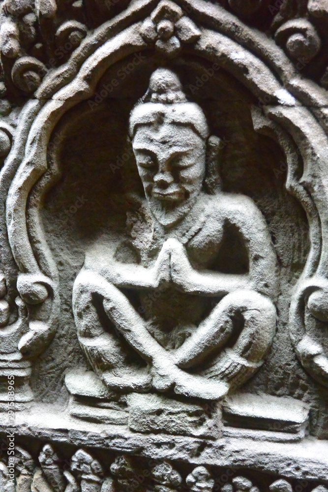 Stone bas-relief of a praying monk carved on the wall of the temple