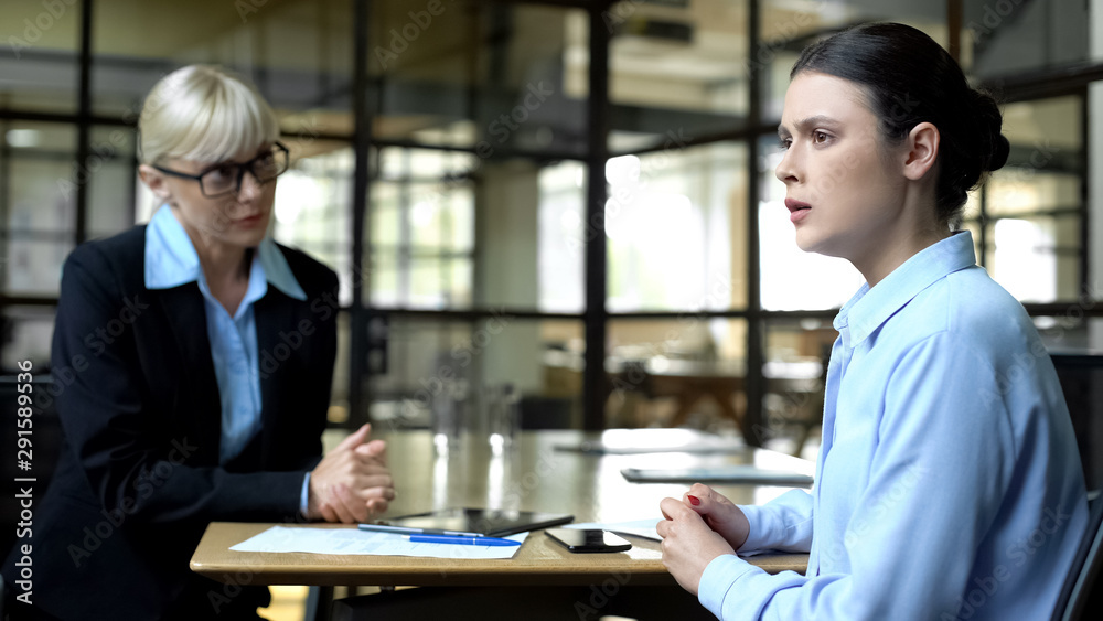Scared woman at job interview with strict lady boss, business career development