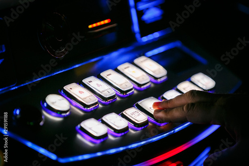 The man presses the button. Casino. Gaming machine buttons. Inscriptions in Russian: payout, hold 1-5, rules, game selection, autostart, START, double, maximum bet, bet.  photo