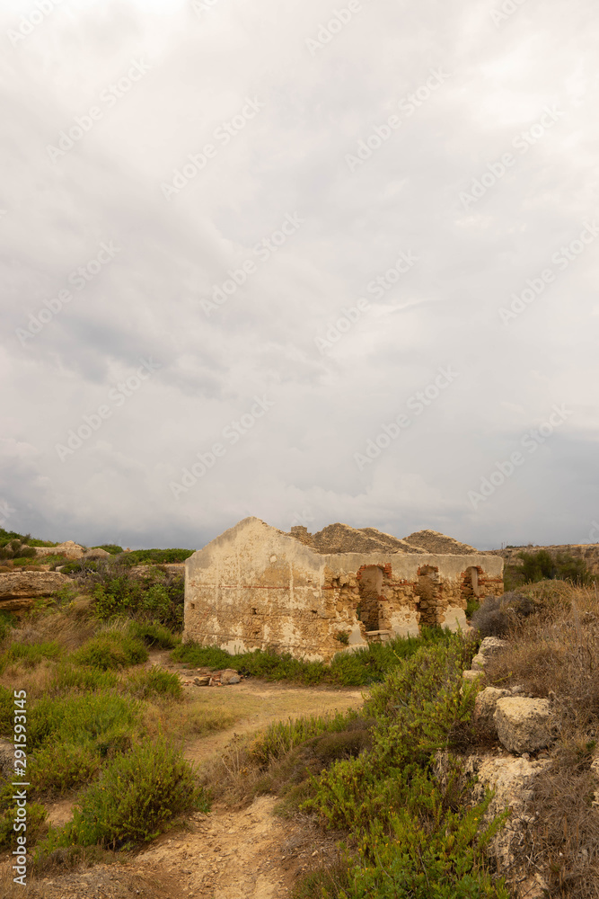 Ruines d'une maison sous un ciel nuageux et menaçant Ruines d'une maison sous un ciel nuageux et menaçant