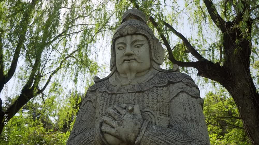 Low angle view of stone Chinese Warrior Statue against trees - Beijing, China Low angle view of stone Chinese Warrior Statue against trees - Beijing, China