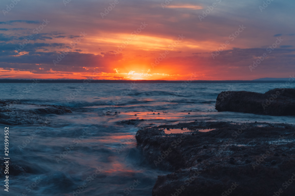 Sunset over ocean rocks