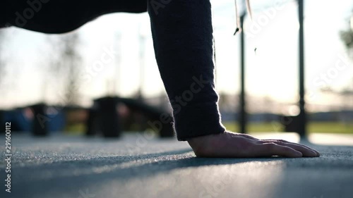 A man doing a push up in a park on cold weather. Close up view. He has steam coming out of his mouth