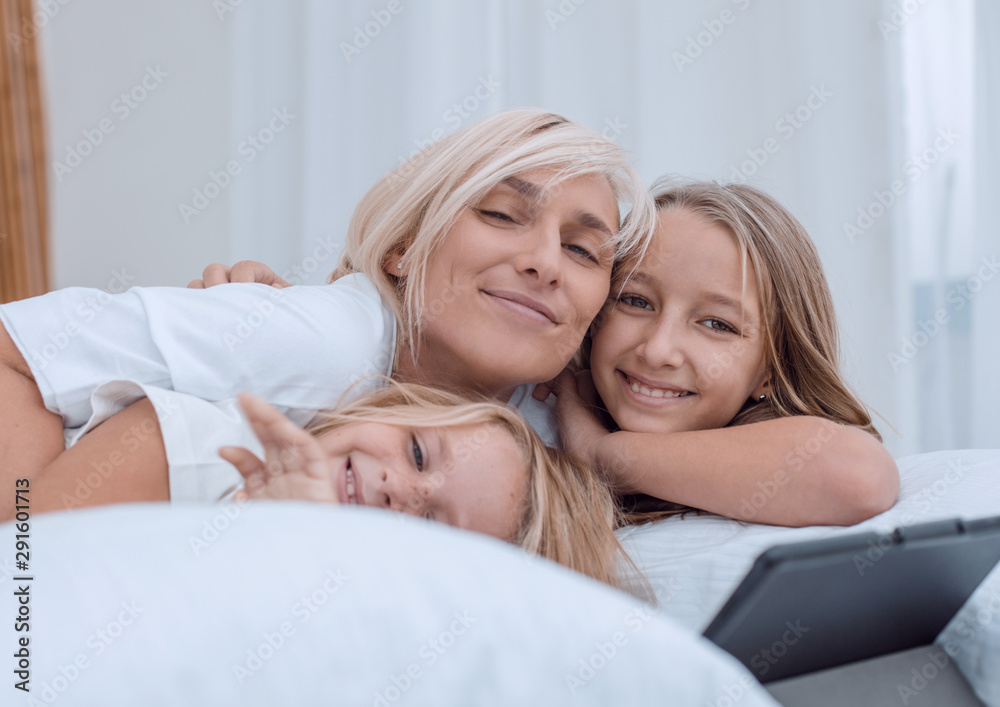 close up. happy mother and children lying on the bed. close up. happy mother and children lying on the bed.